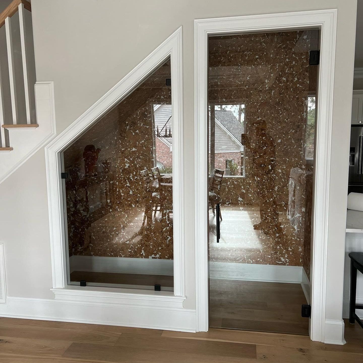 A room with a staircase and a glass door leading to it.