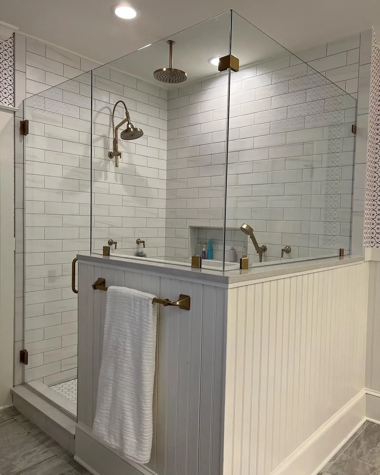 A bathroom with a walk in shower with a glass door