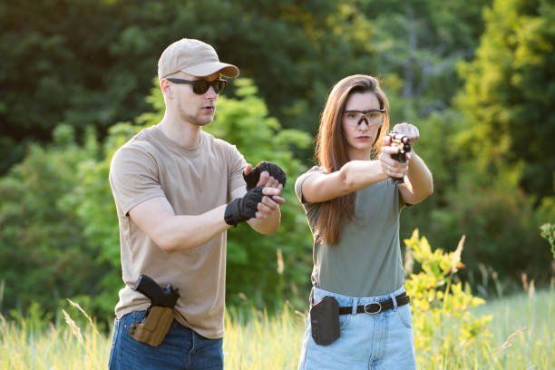 Learns to shoot a pistol with an instructor