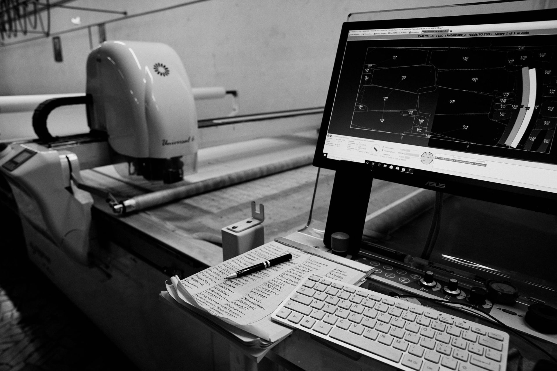 Un computer è posizionato su una scrivania accanto a una macchina.