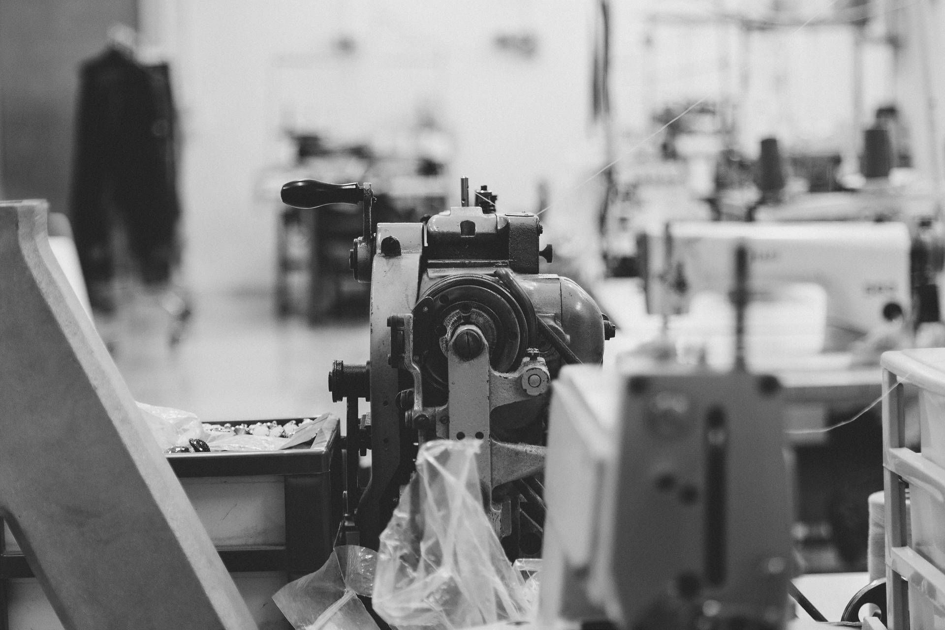 Una foto in bianco e nero di una macchina da cucire in una fabbrica.