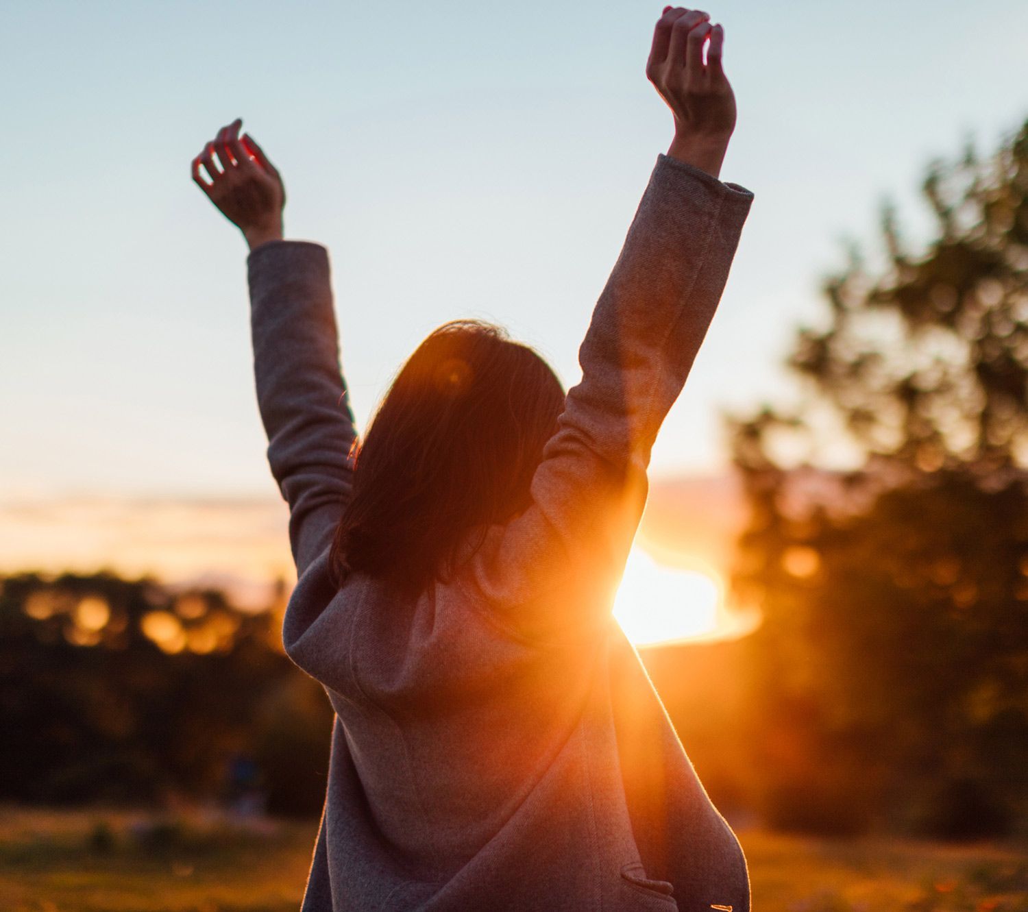 Woman Looking on Sunset and Raising her Hands Woman Looking on Sunset and Raising her Hands