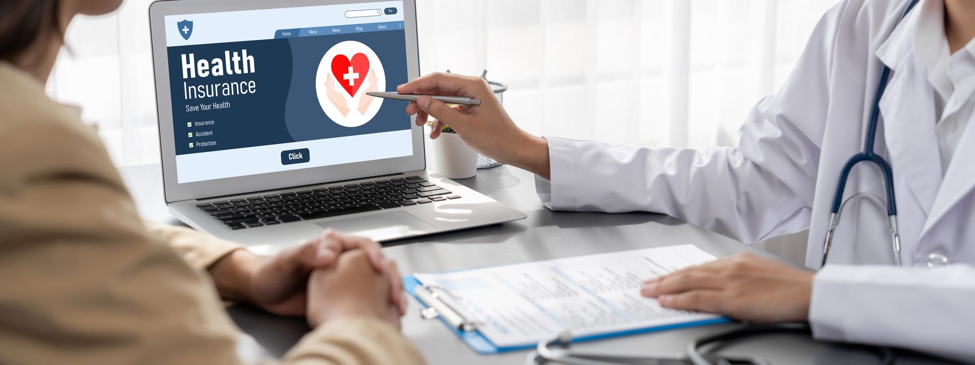 Doctor pointing to health insurance information on a laptop screen while consulting a patient.