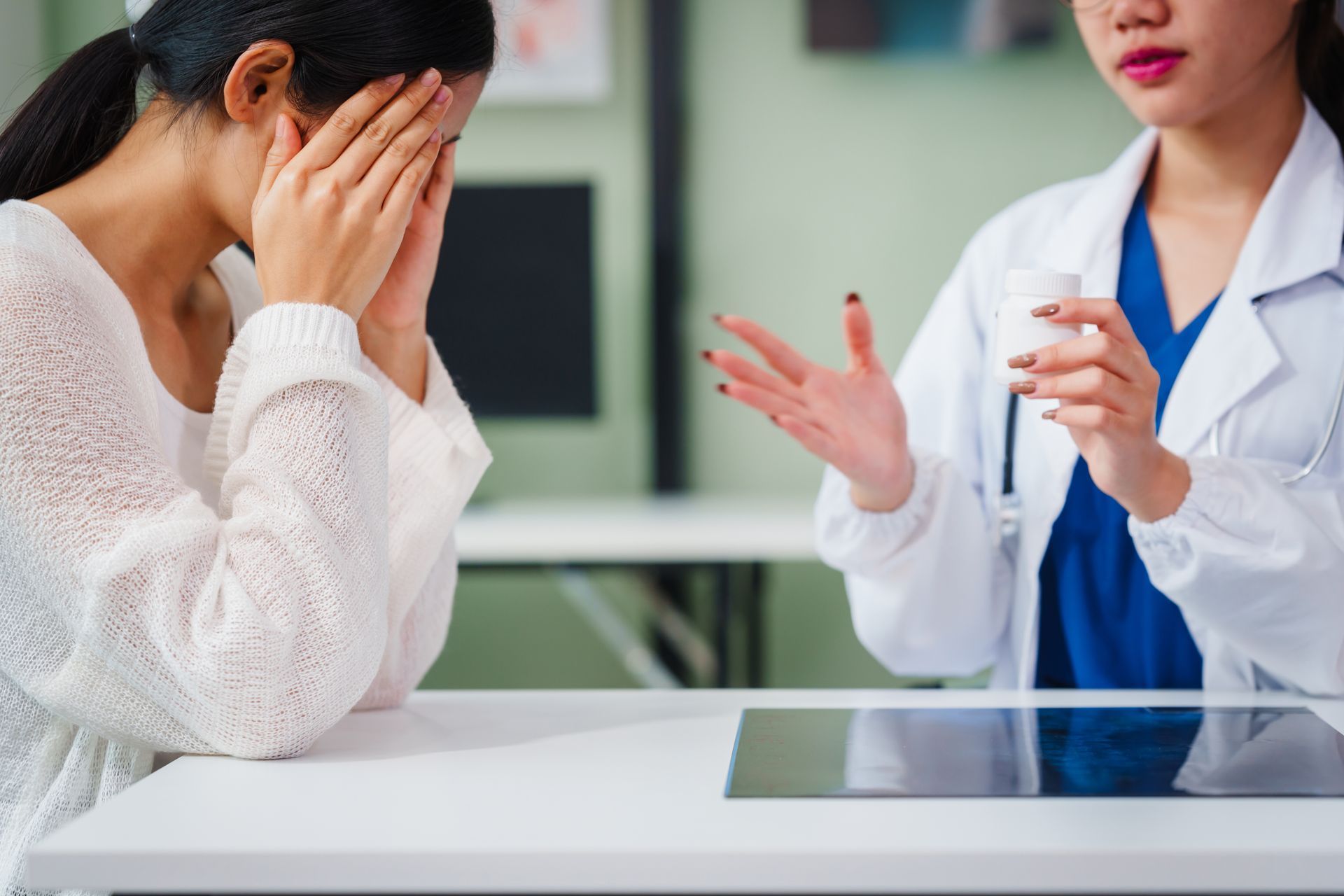 Doctor explaining medication to a distressed patient in an office setting.