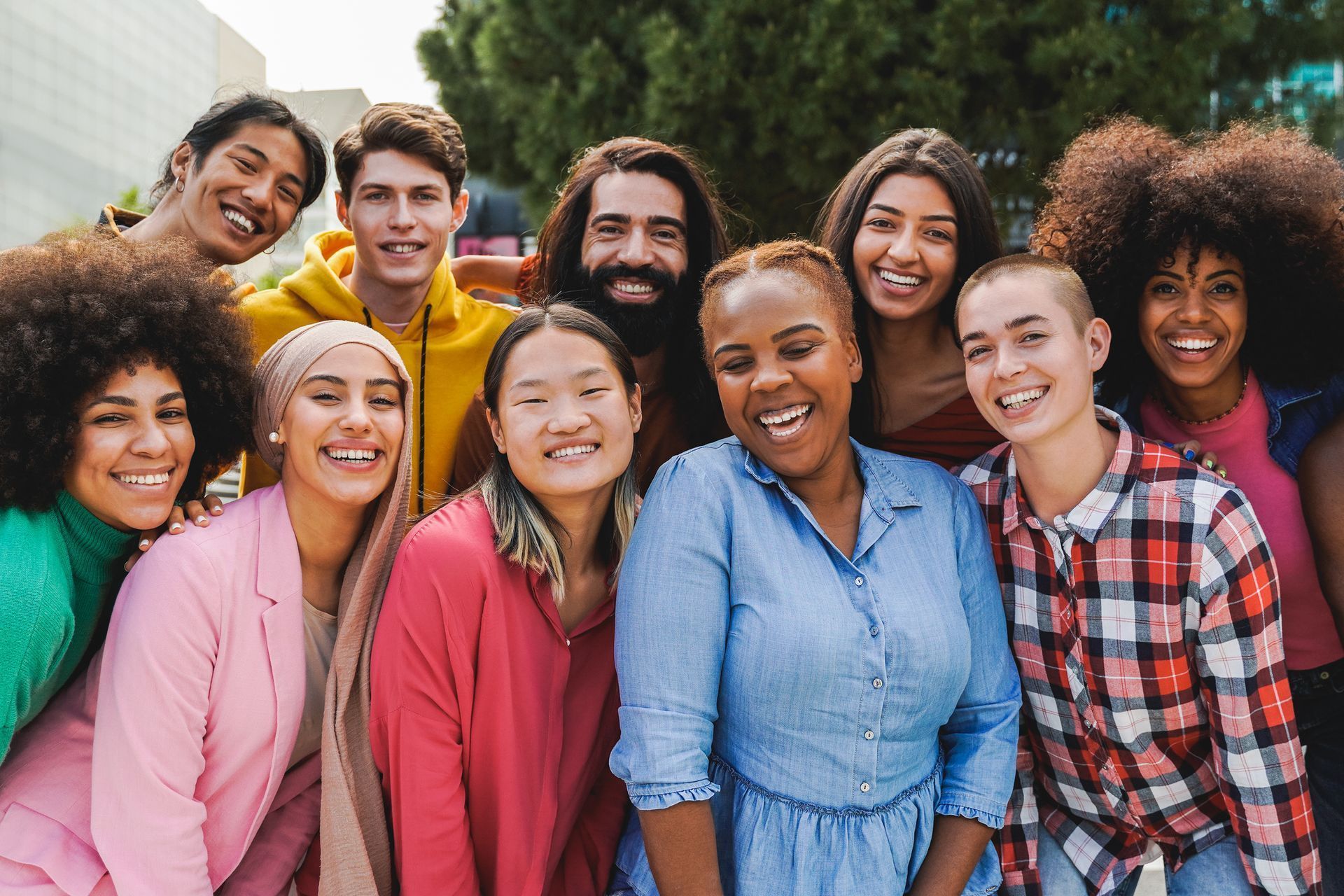 Group of diverse people smiling and posing outdoors.