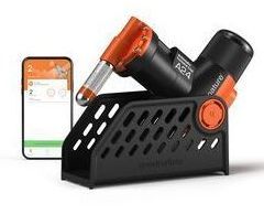 A device is sitting on top of a holder next to a cell phone.