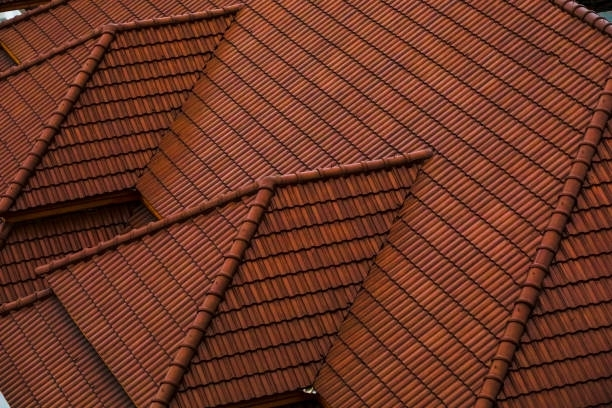 Angled view of terracotta roof tiles on multiple connected roof sections.