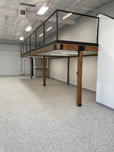 A large empty room with a balcony and a concrete floor.