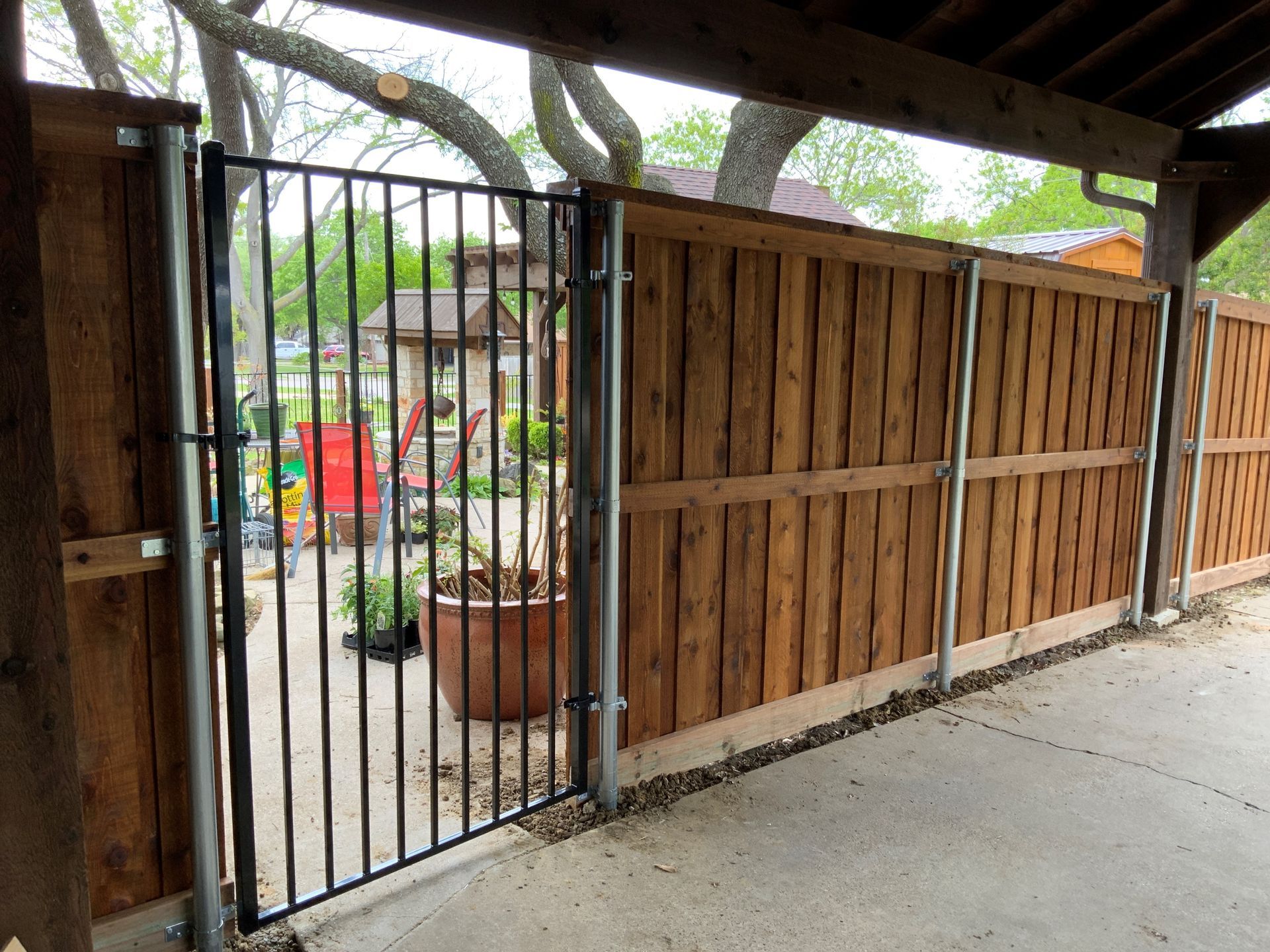 A wooden fence with a metal gate in front of it