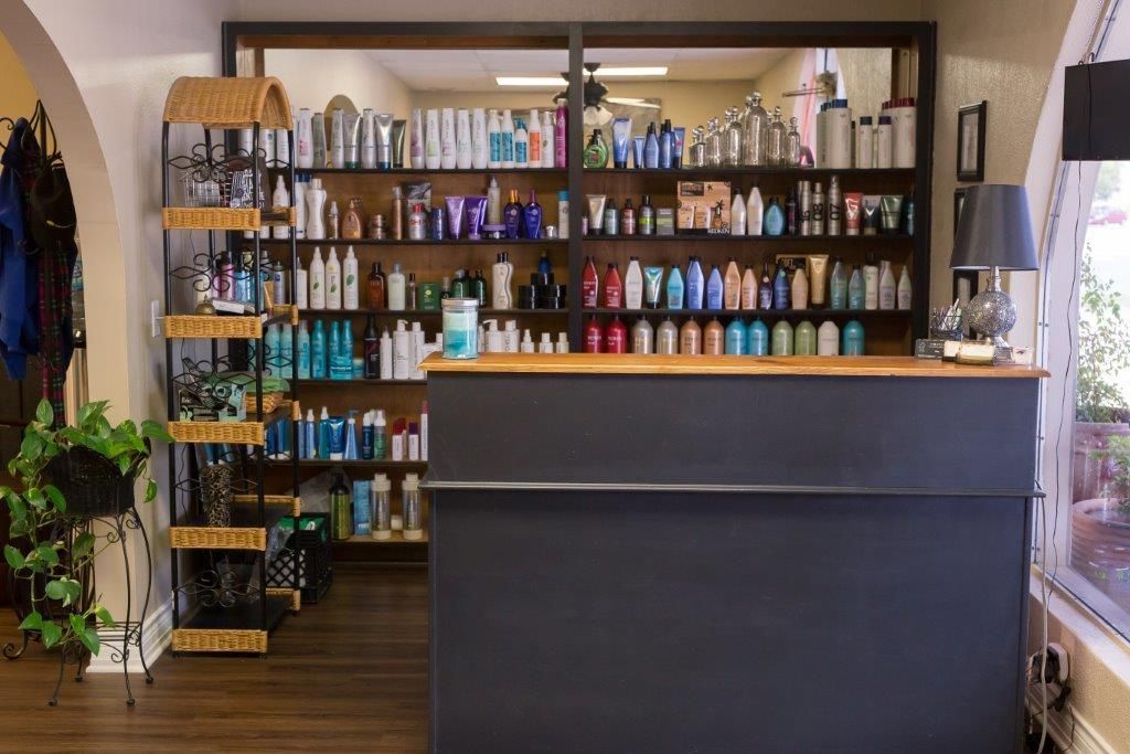A salon with a counter and shelves filled with hair products.