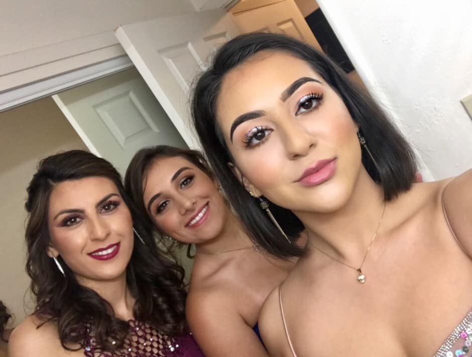 Three women are posing for a picture together and smiling