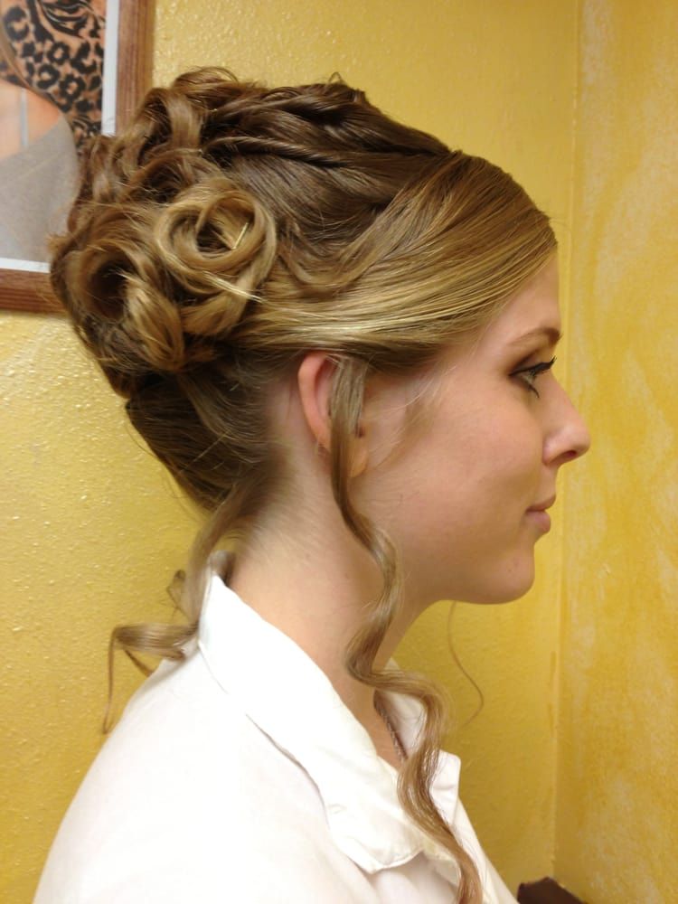 A woman in a white shirt has her hair in a bun