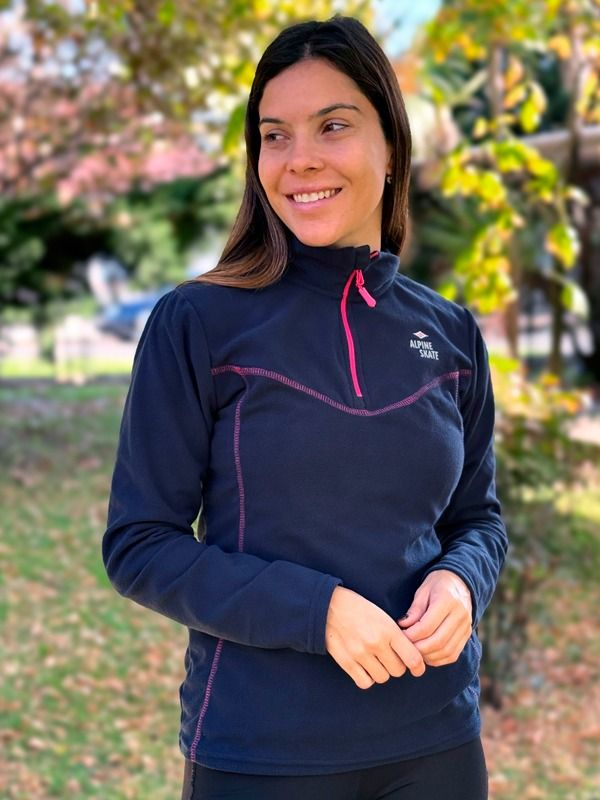 Una mujer lleva una sudadera azul y sonríe.