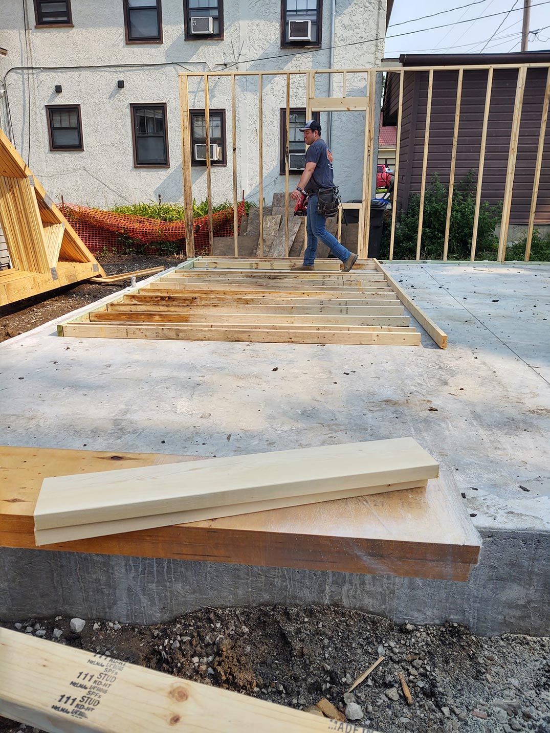 A man is standing in front of a building under construction.