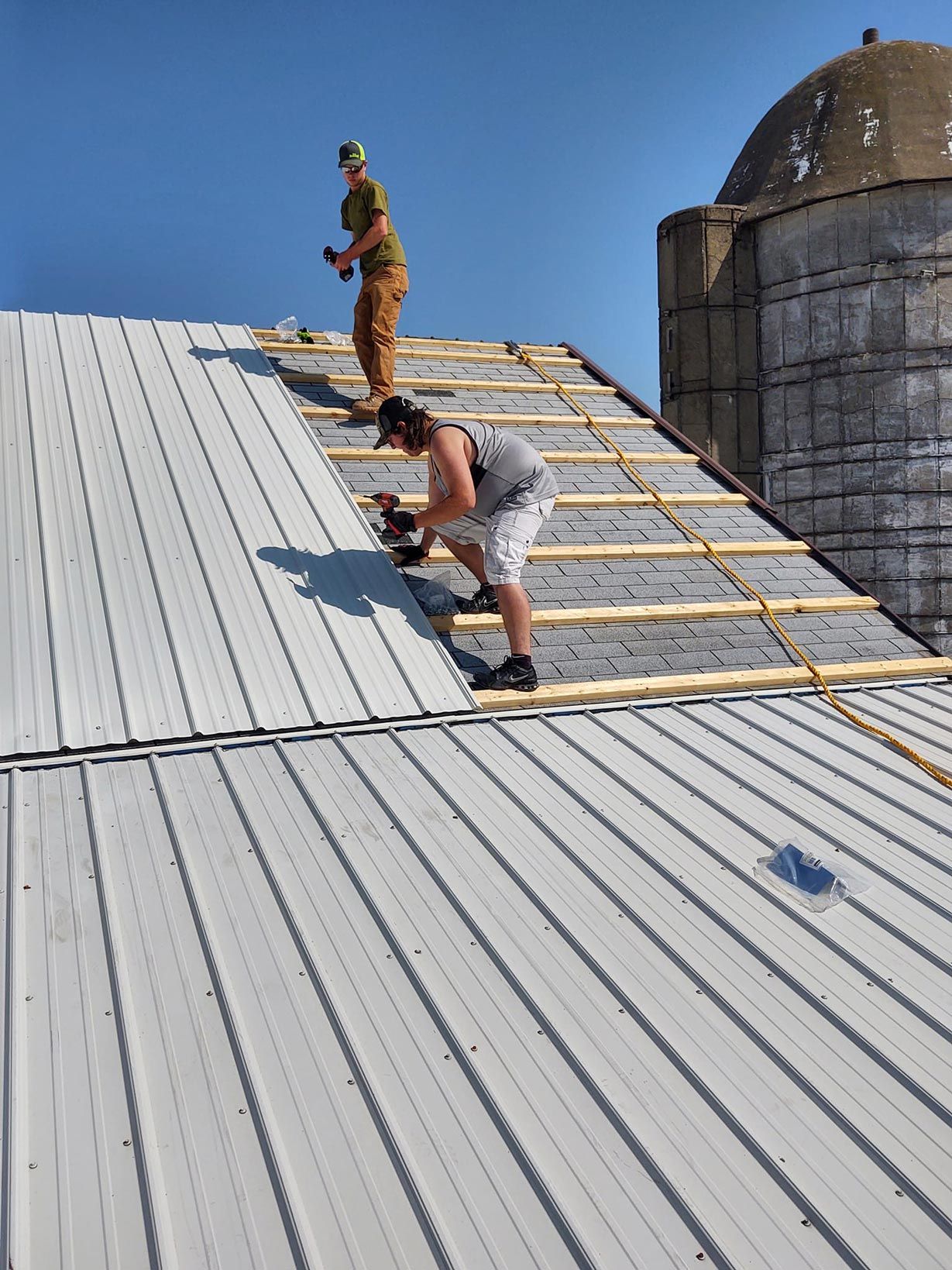 Two men are working on the roof of a building