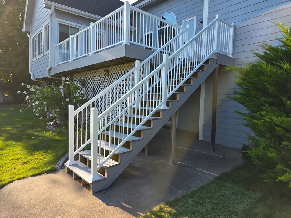 A white deck with stairs leading up to it