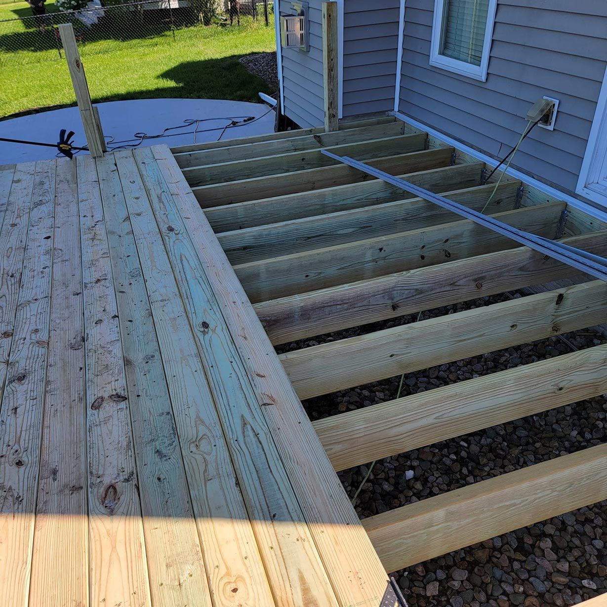 A wooden deck is being built in front of a house.