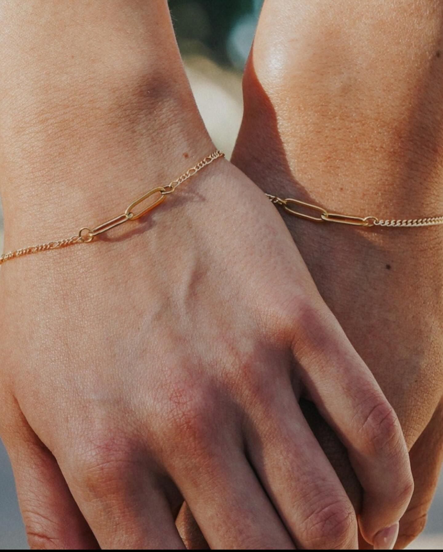 Two people wearing gold bracelets on their wrists