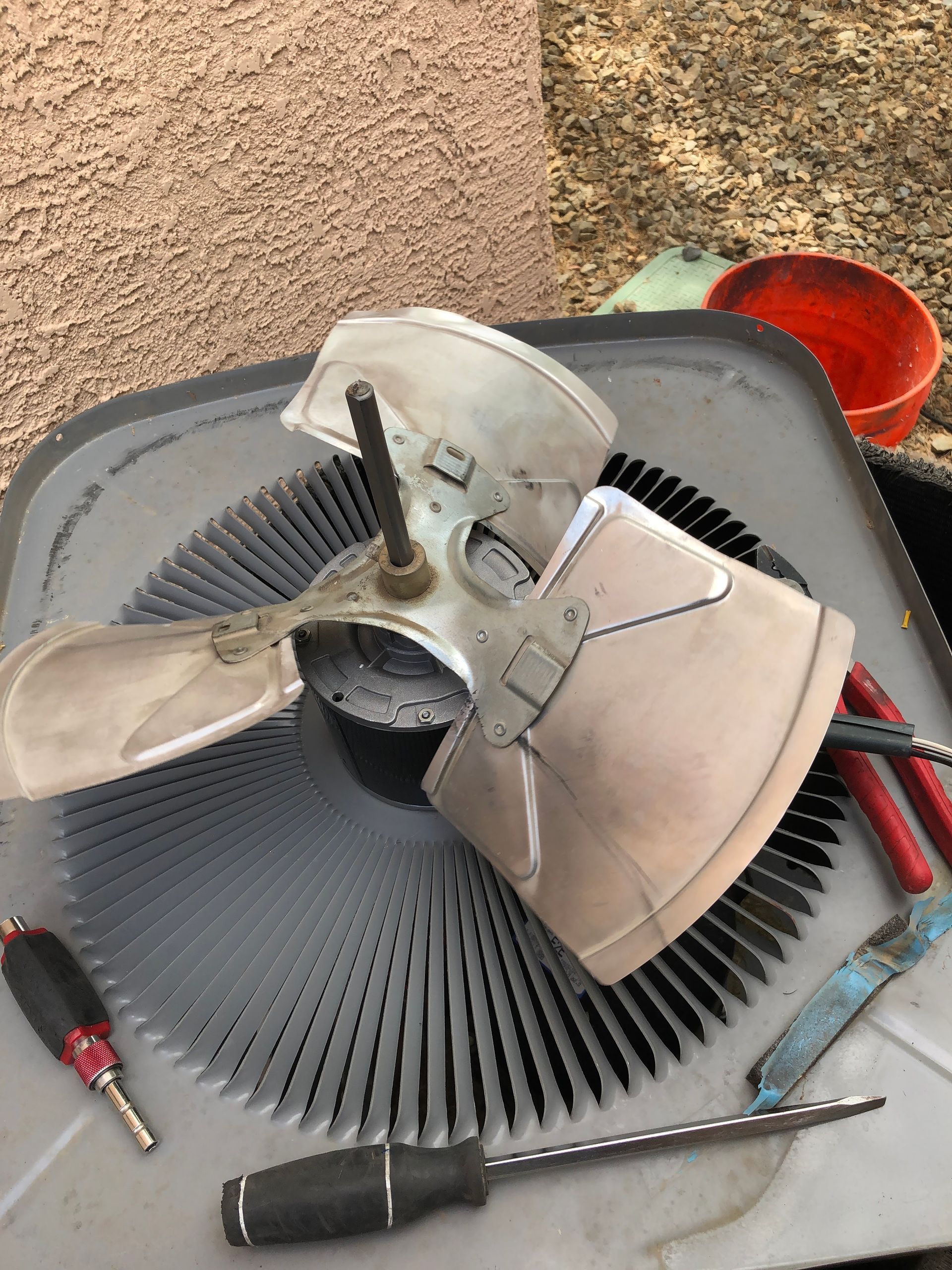 A furnace is being repaired in a garage with a voltmeter attached to it.