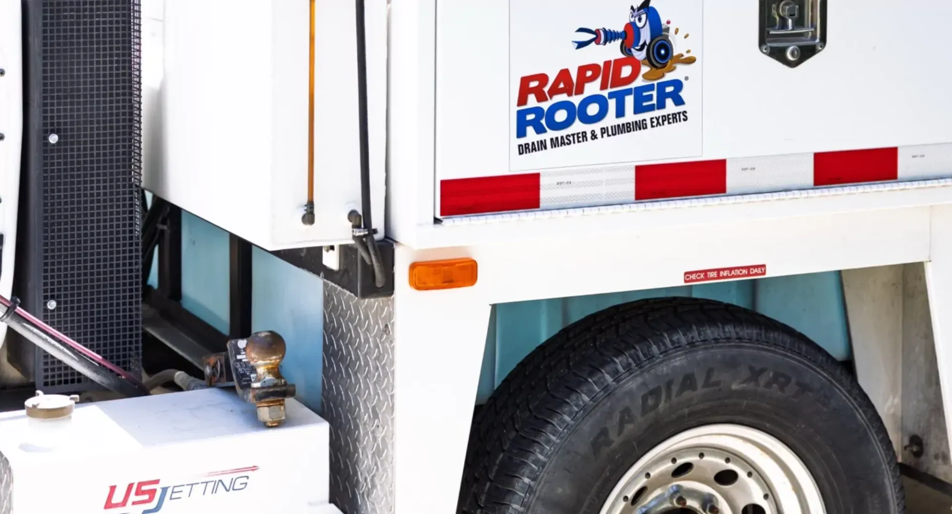 A white truck with a rapid rooter sticker on the side