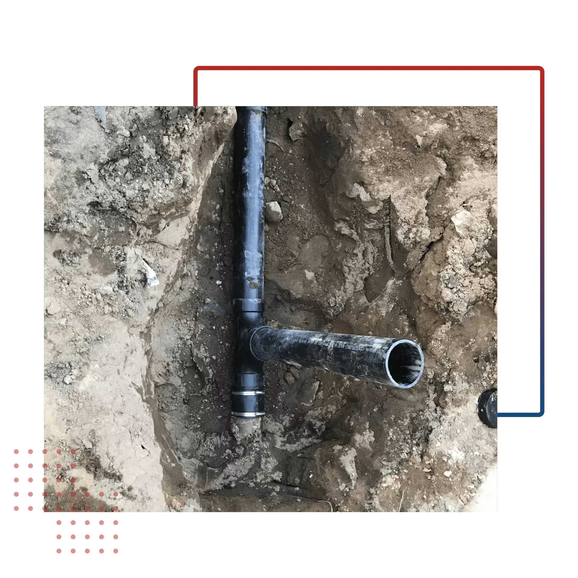 A black pipe is sitting in the dirt in the ground.