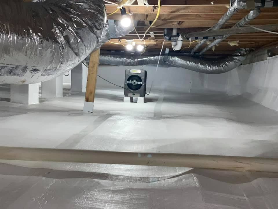 There is a fan in the ceiling of a basement.