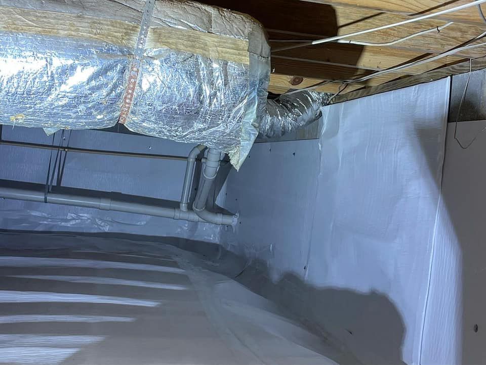 A picture of a basement with a duct hanging from the ceiling.