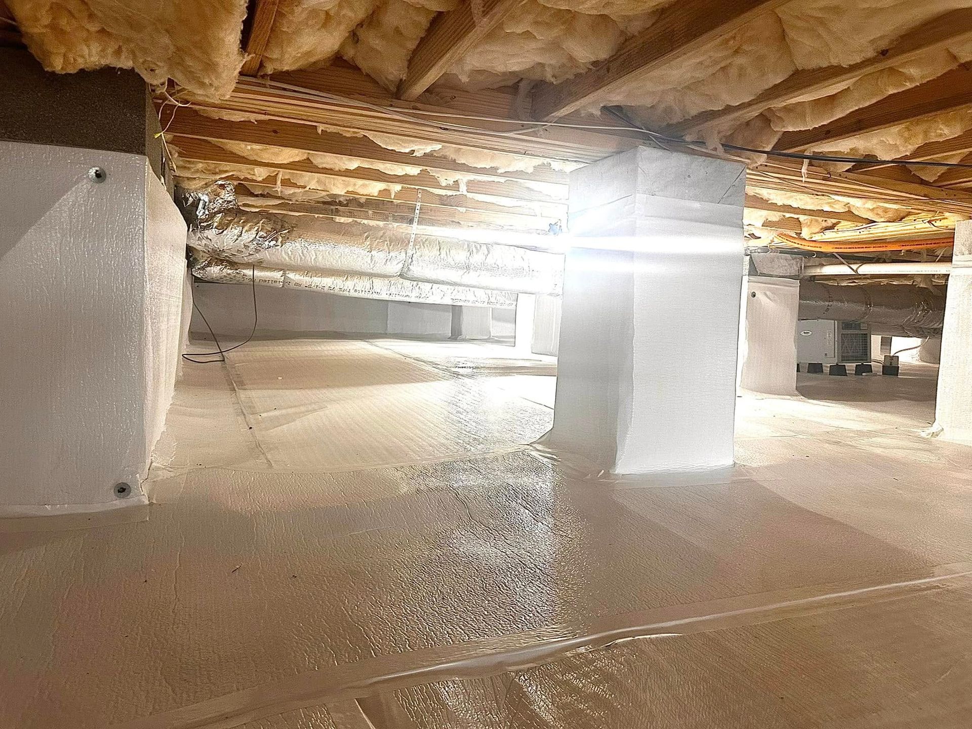 A basement with a lot of insulation and a light on the ceiling.