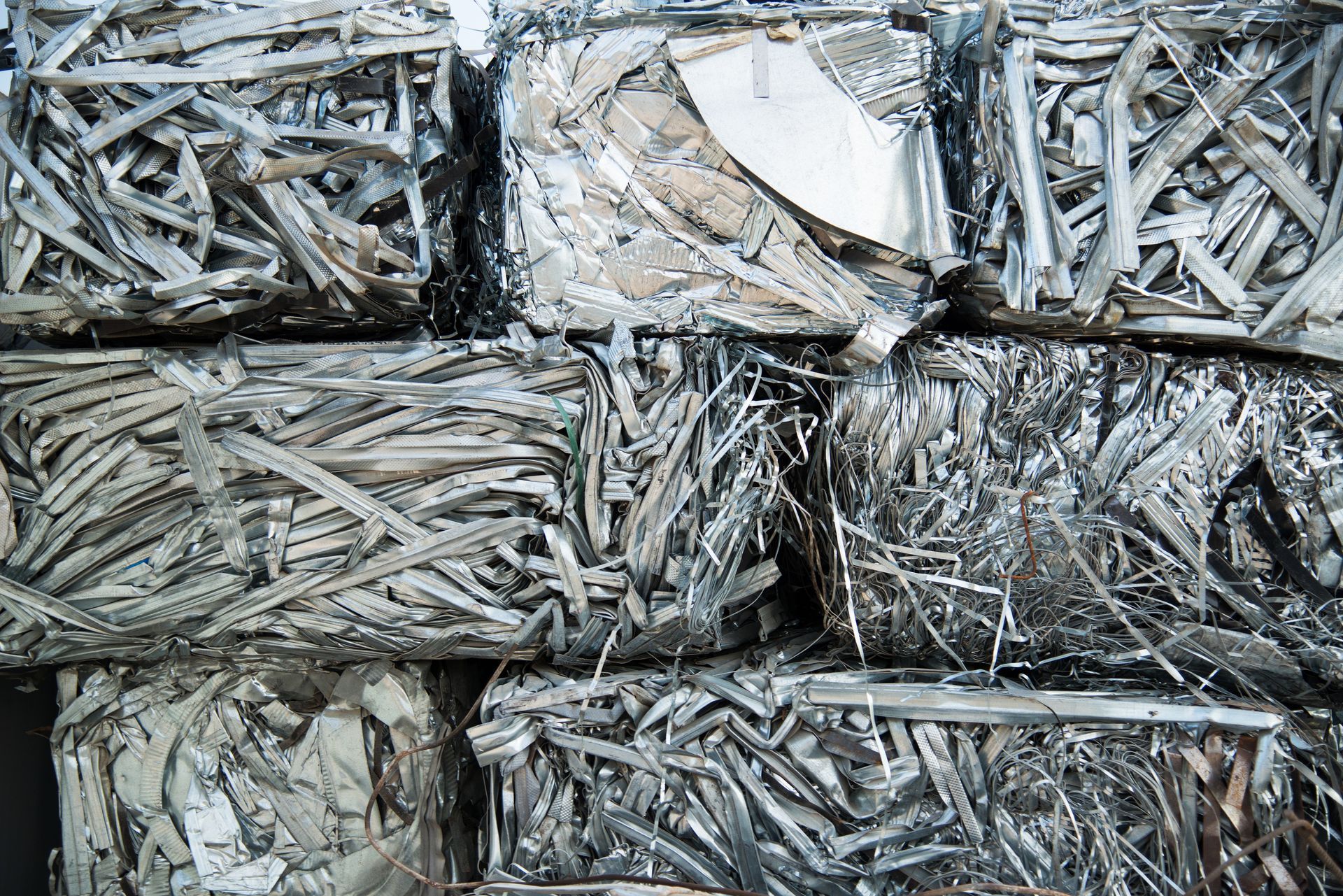 Large pile of scrap metal pieces stacked at an industrial recycling site.