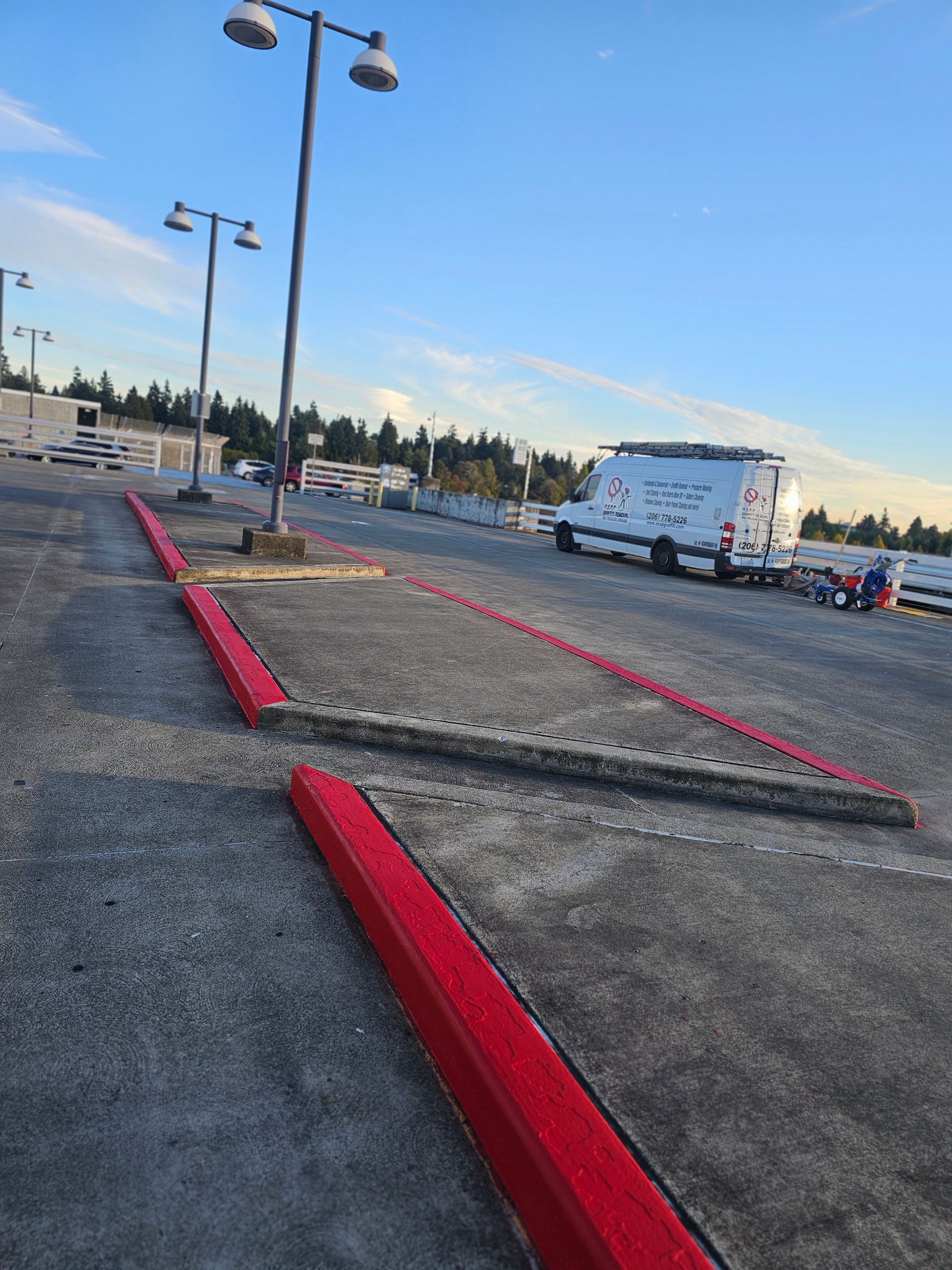 Exterior view of building with glass windows, orange traffic cones, and a green awning.