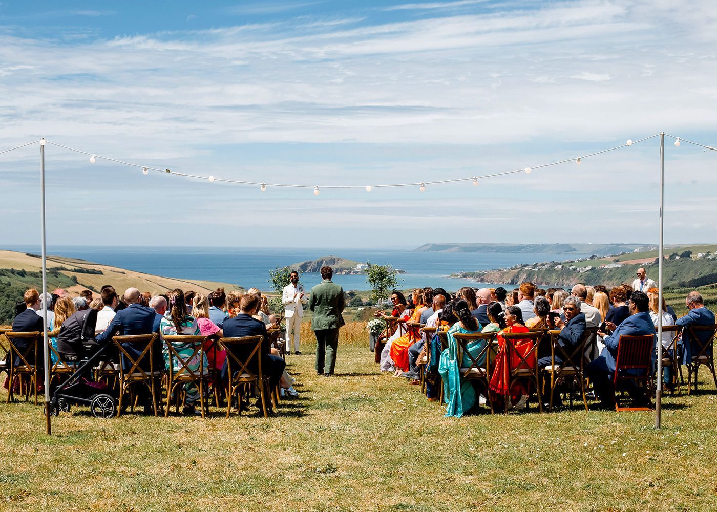 A large group of people are sitting in chairs at a wedding ceremony.
