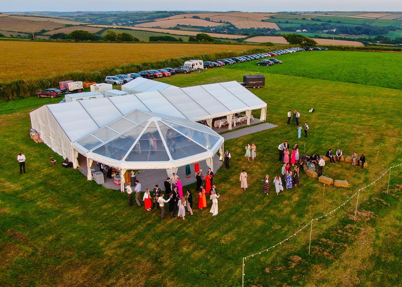 An aerial view of a large tent surrounded by people in a field.