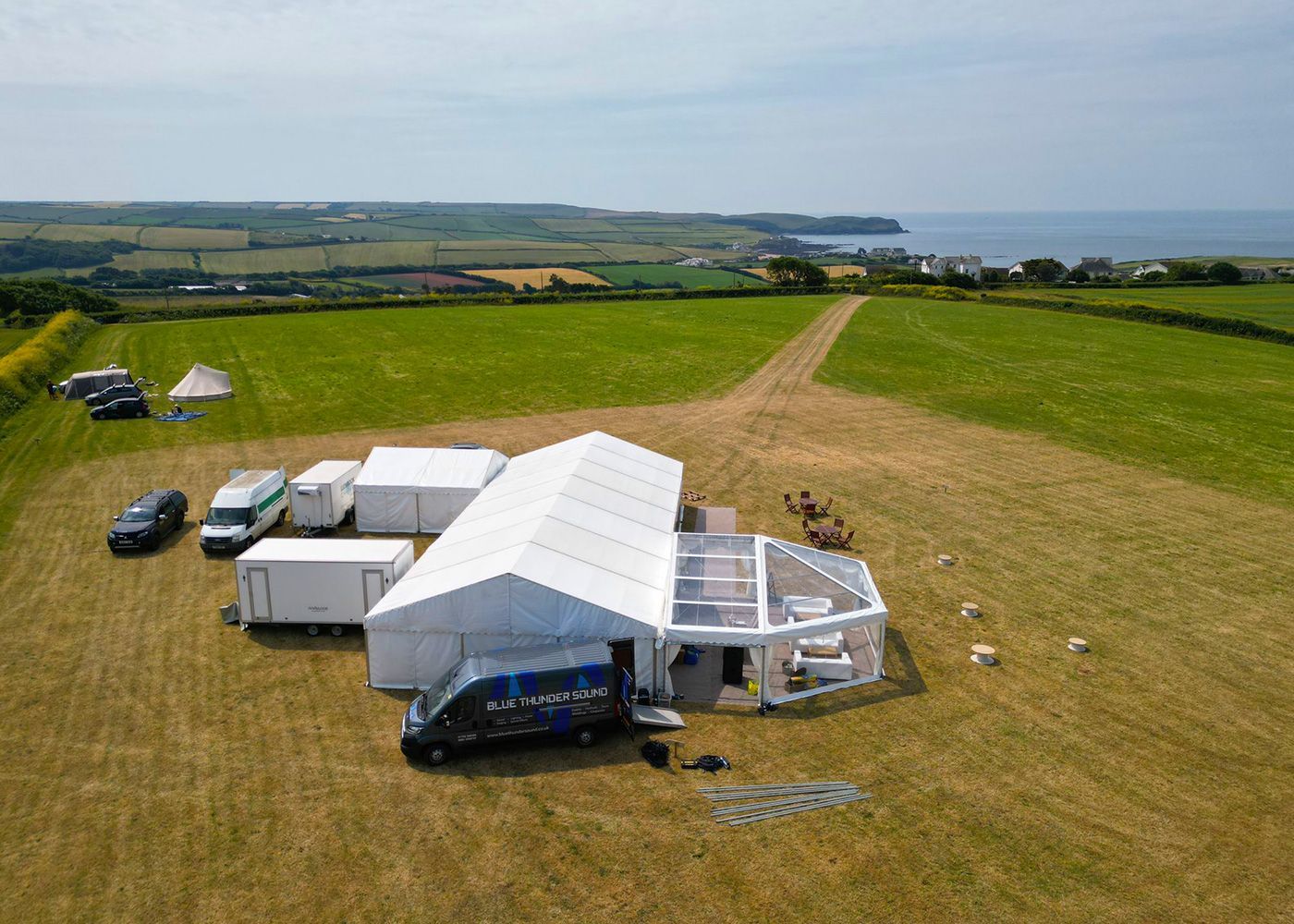 An aerial view of a large white tent in a field.