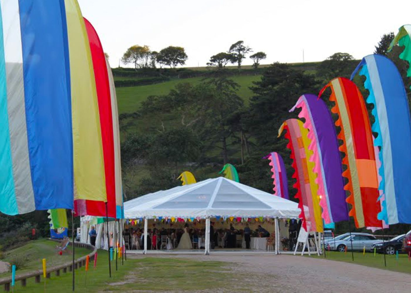 A clear tent is surrounded by colorful flags