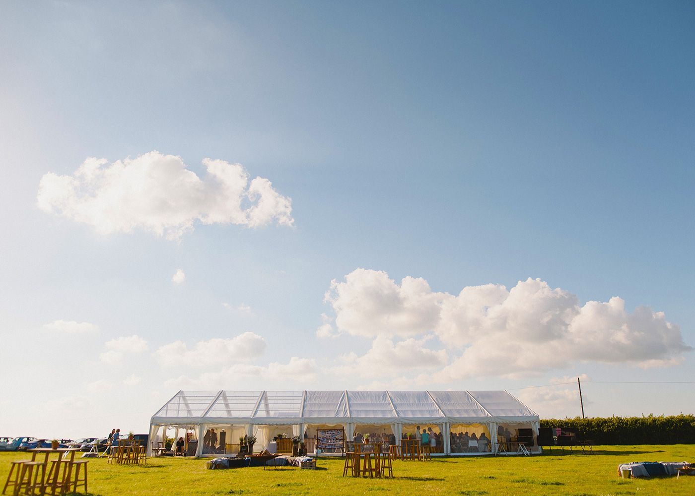 A large white tent is sitting in the middle of a field.
