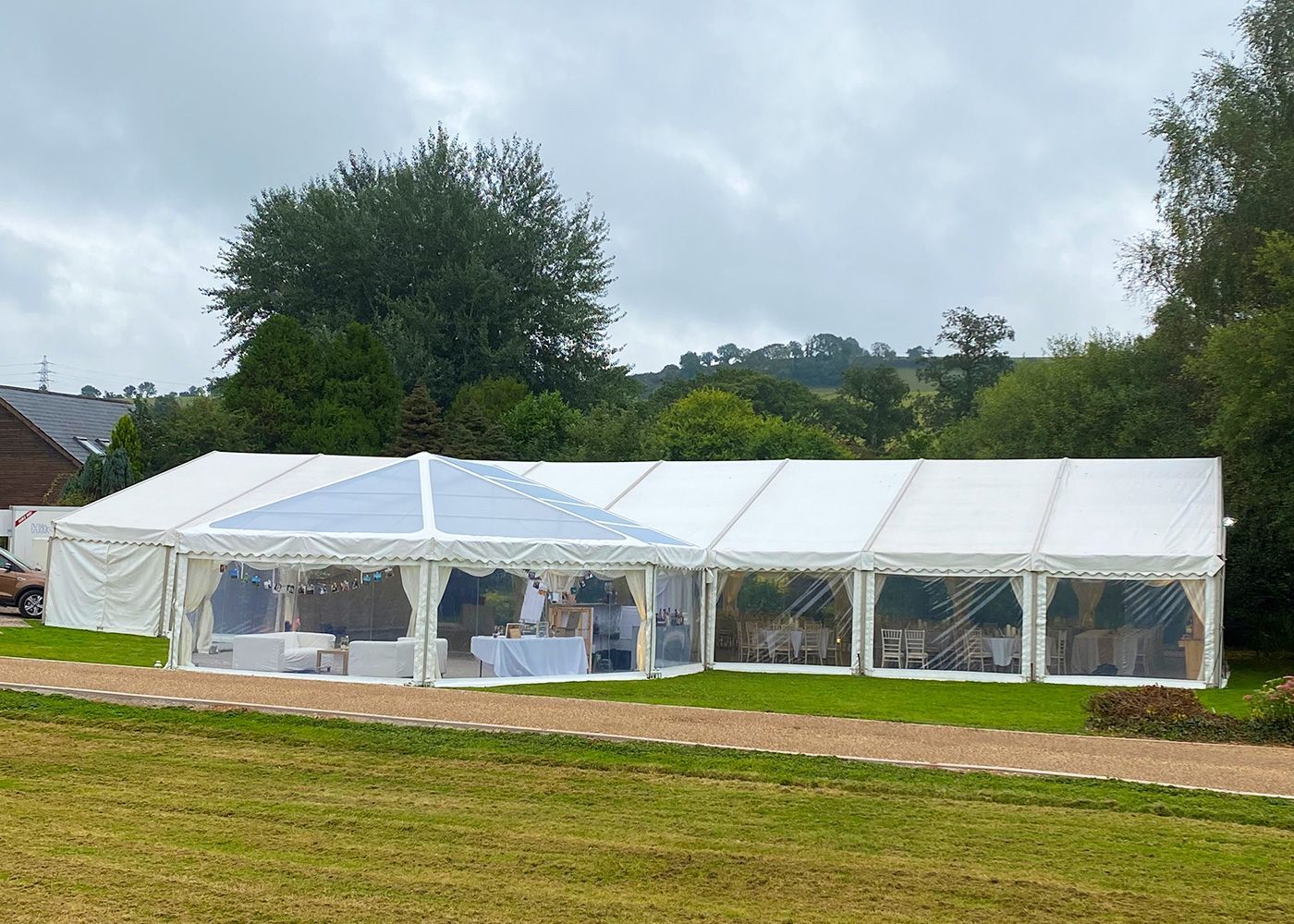A large white tent is sitting in the middle of a grassy field.