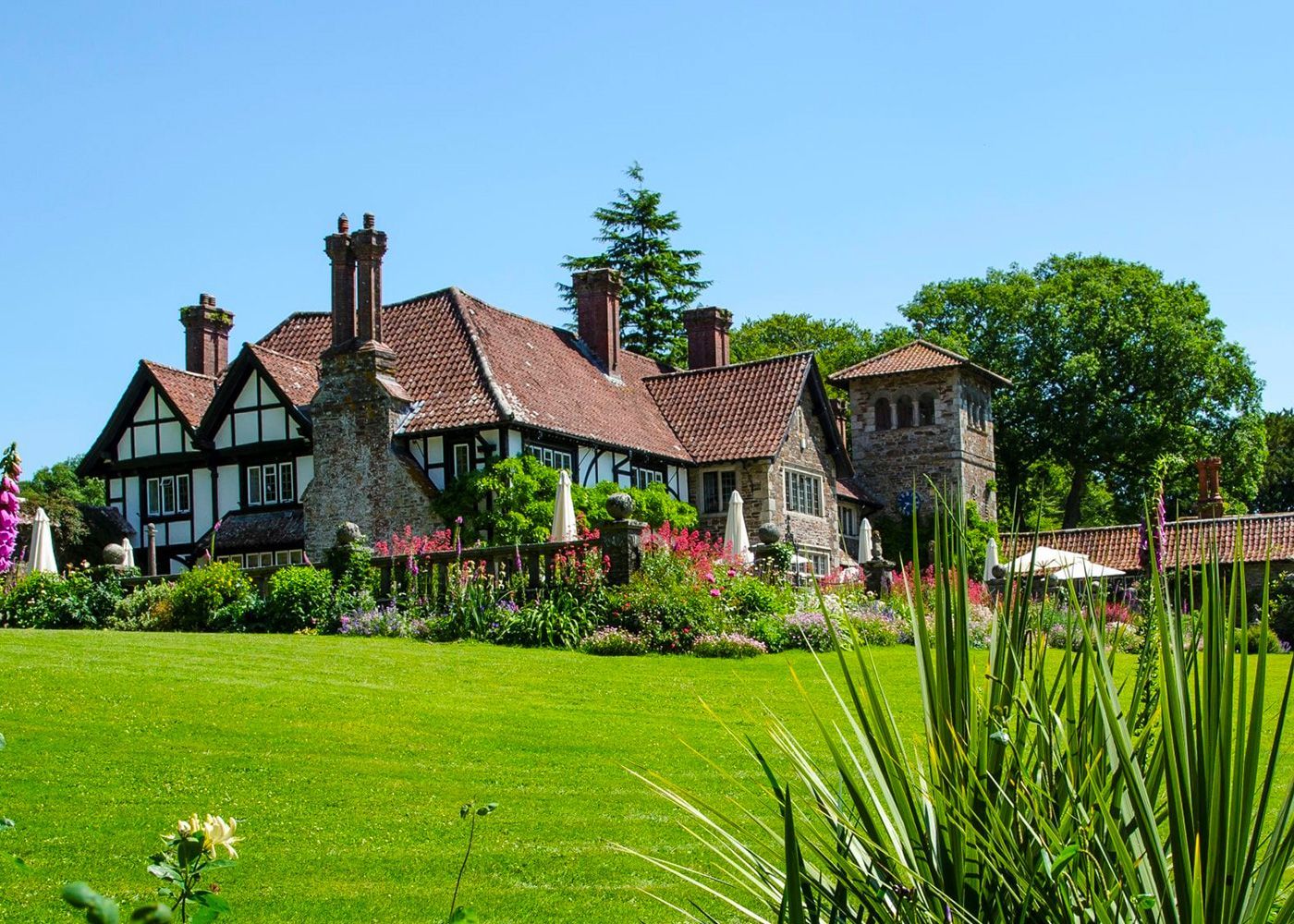 A large house is surrounded by a lush green field