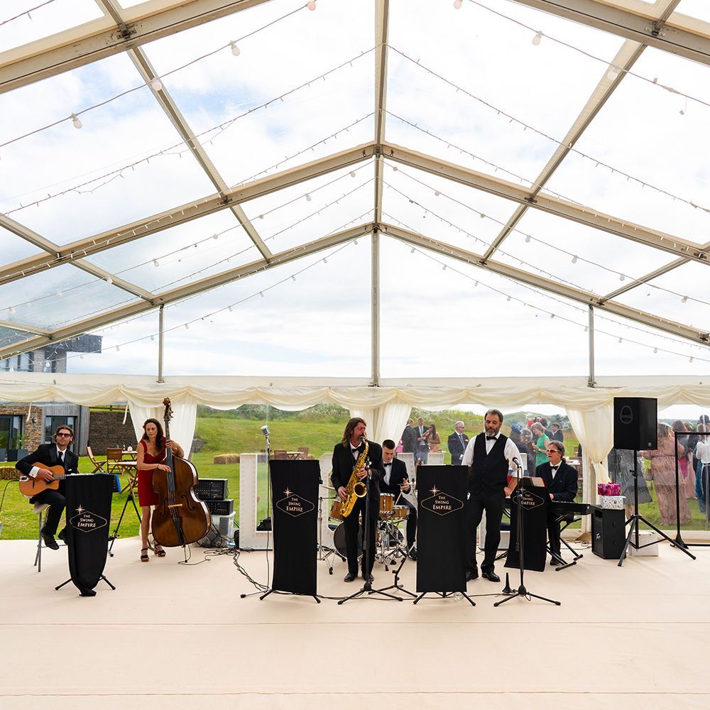 A group of people are playing instruments in a tent.
