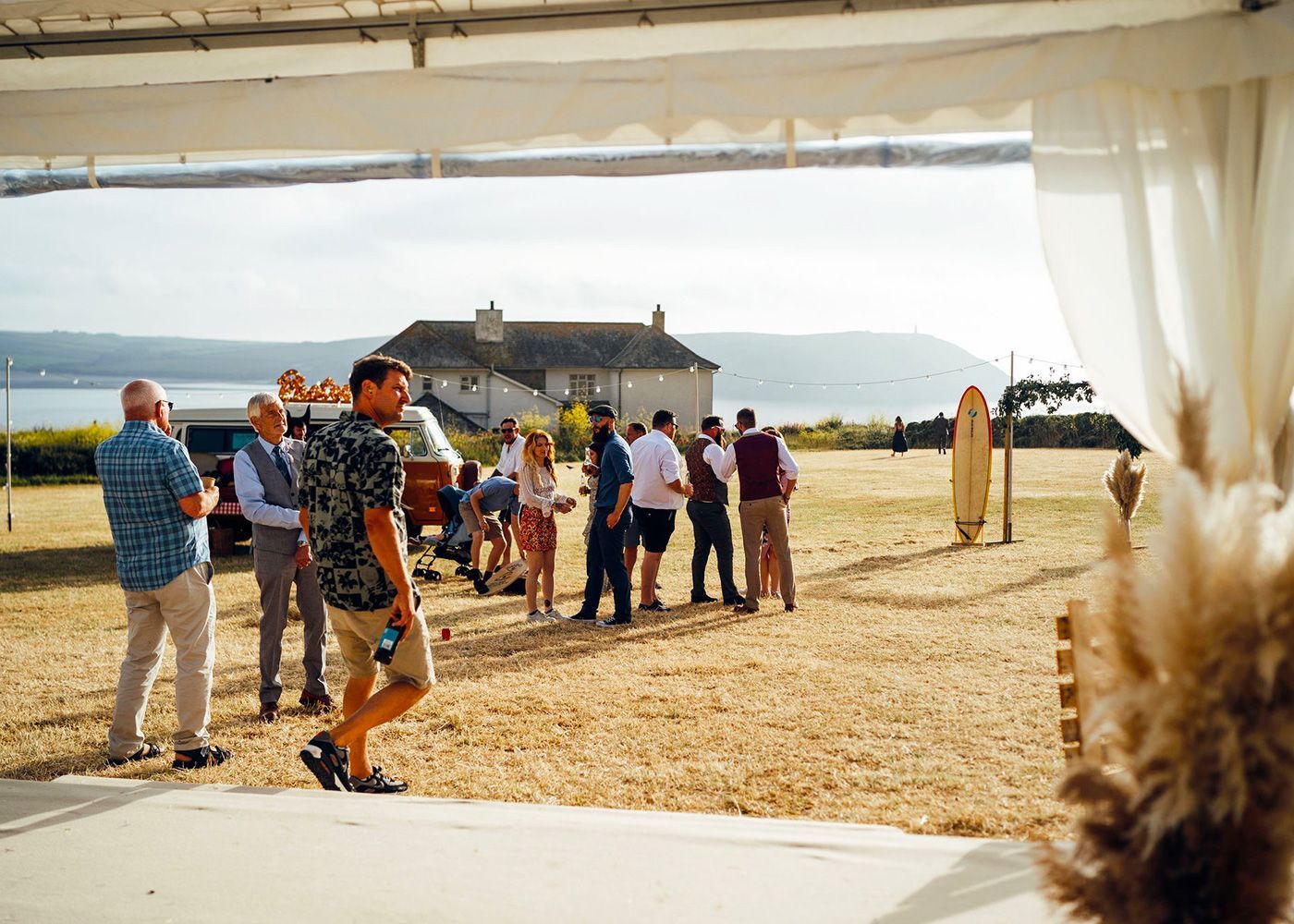 A group of people are standing in a field talking to each other.