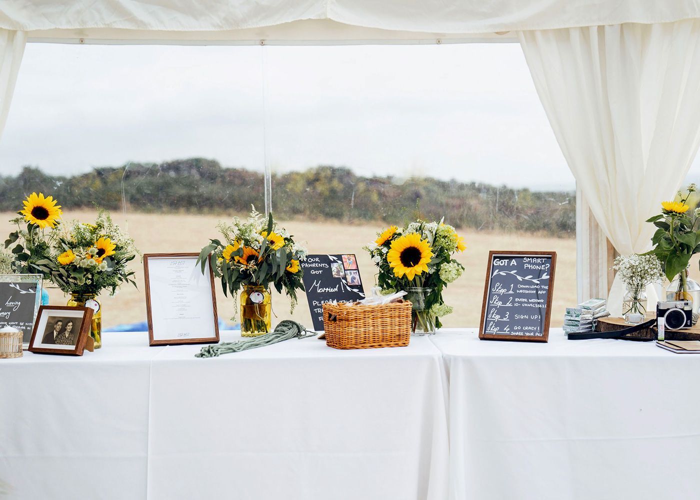 A table with sunflowers , pictures , and signs on it.