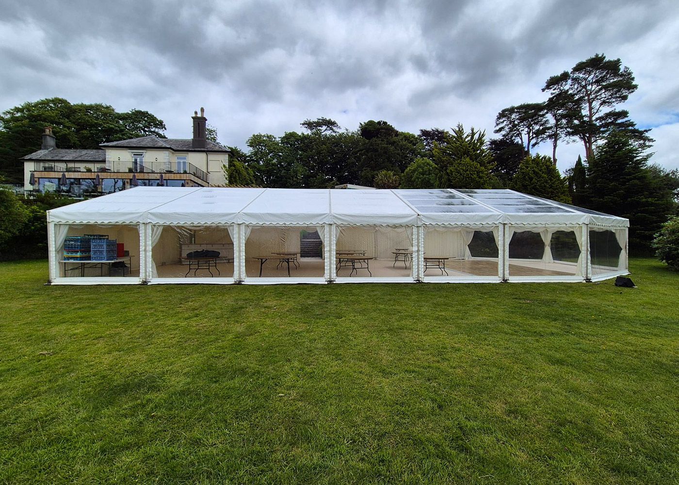 A large white tent is sitting on top of a lush green field.