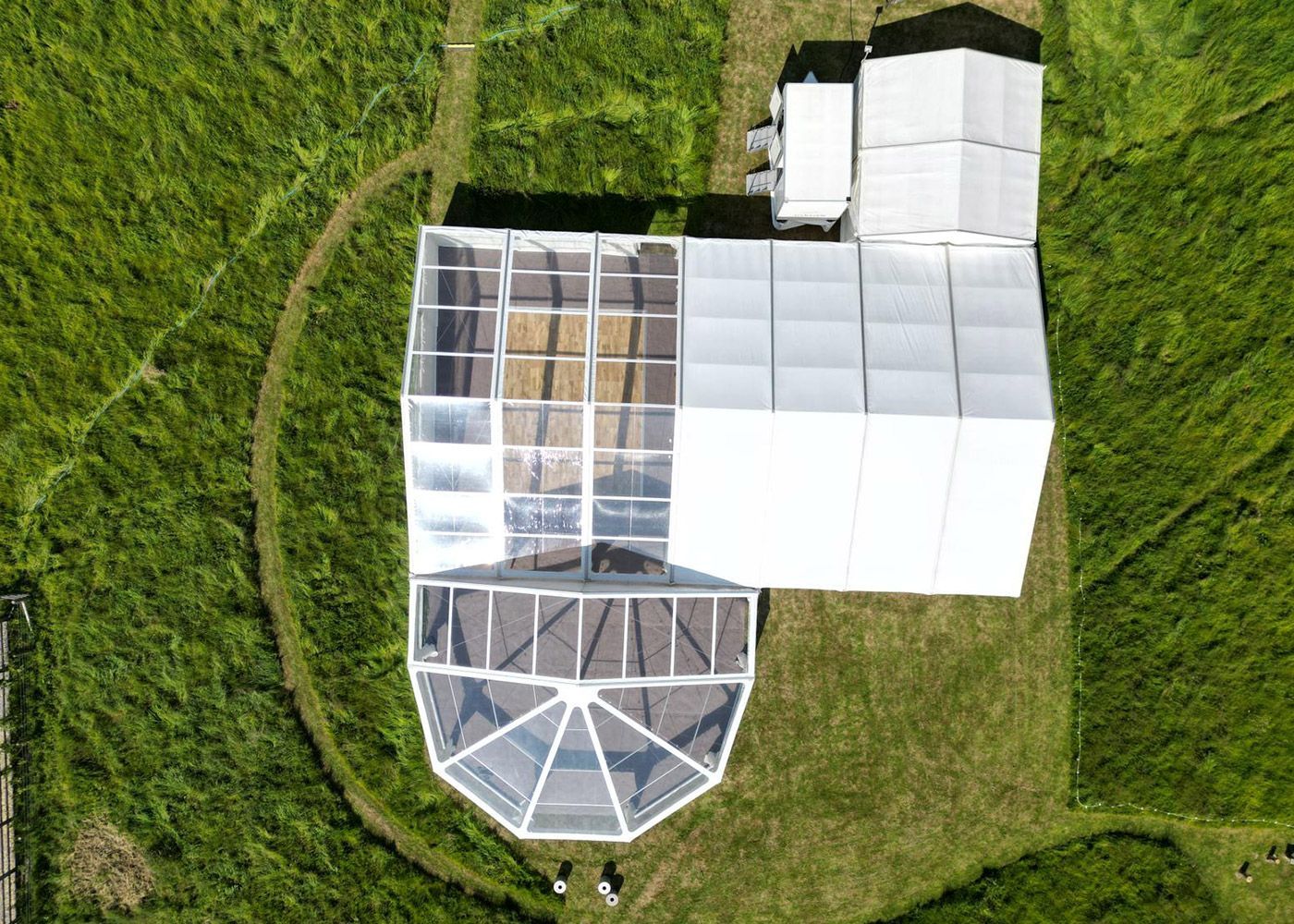 An aerial view of a large tent in the middle of a field.