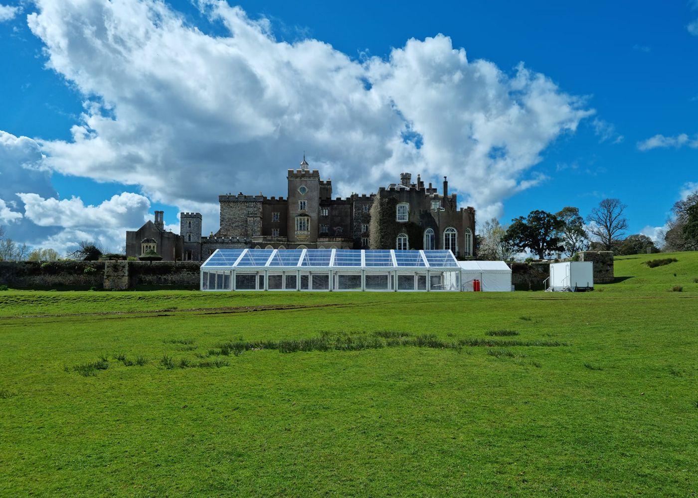 A large castle with a clear tent in front of it.