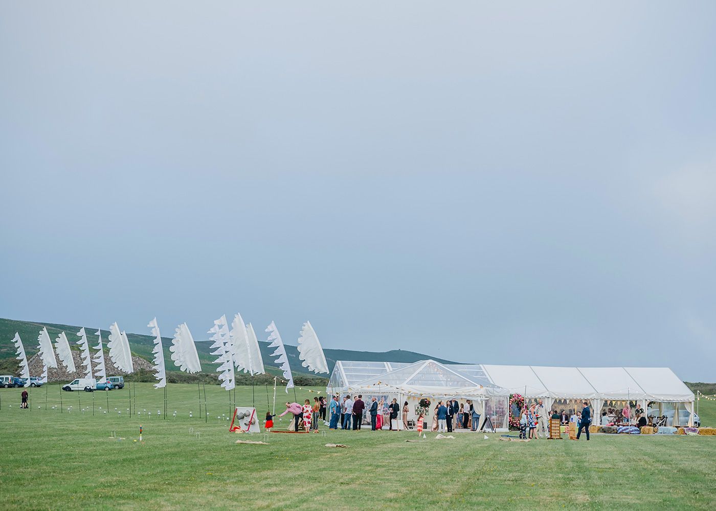A group of people are standing in a field in front of a tent.