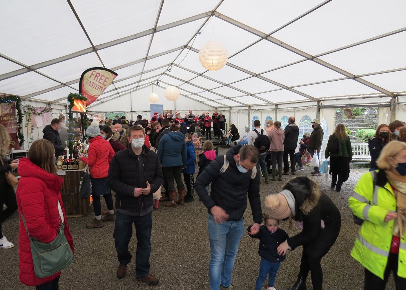 A large group of people are standing under a tent.