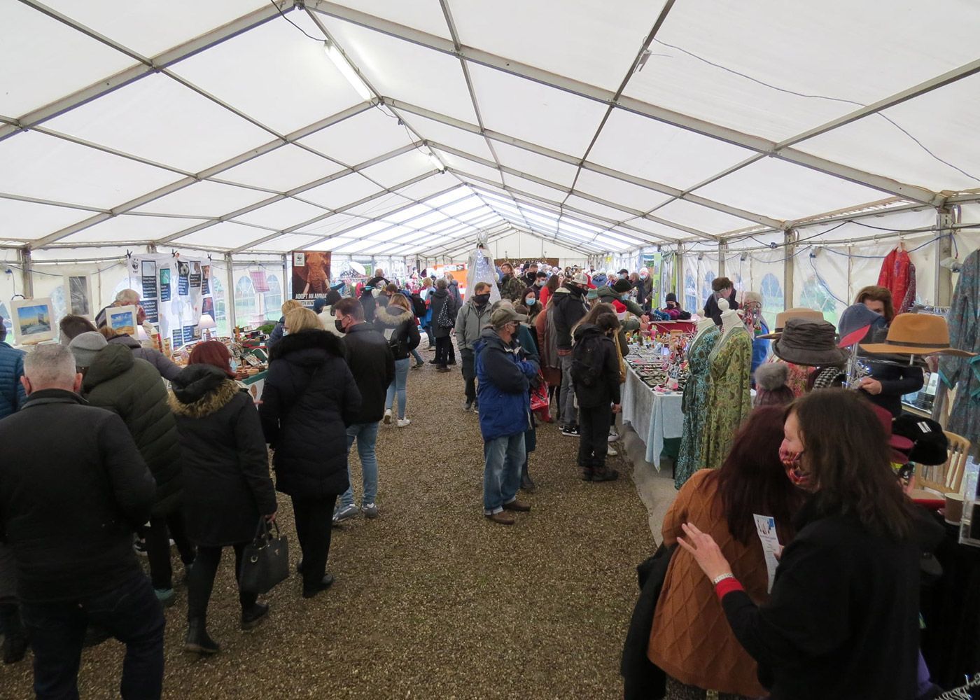 A large group of people are standing inside of a tent.