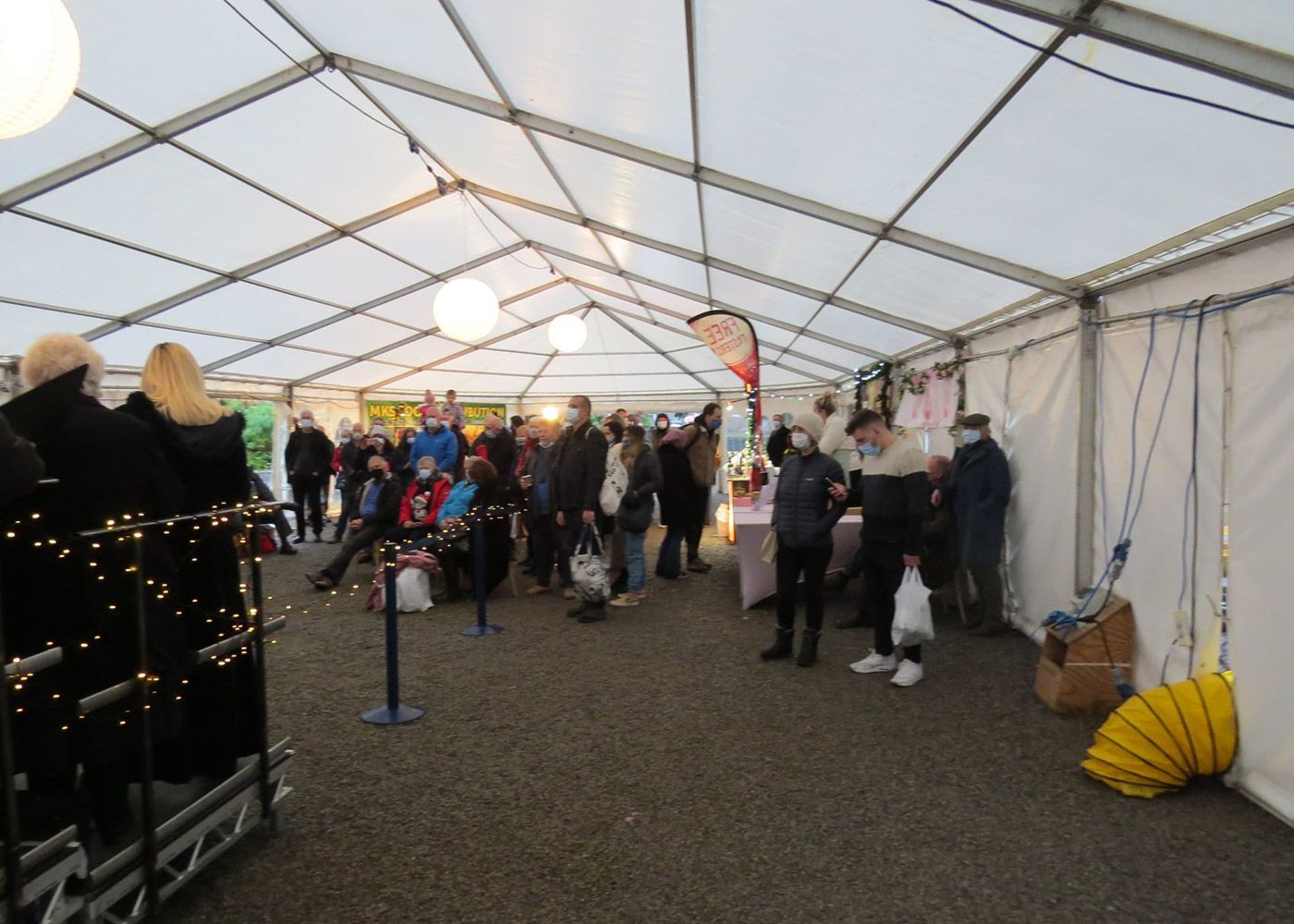 A group of people are gathered under a tent
