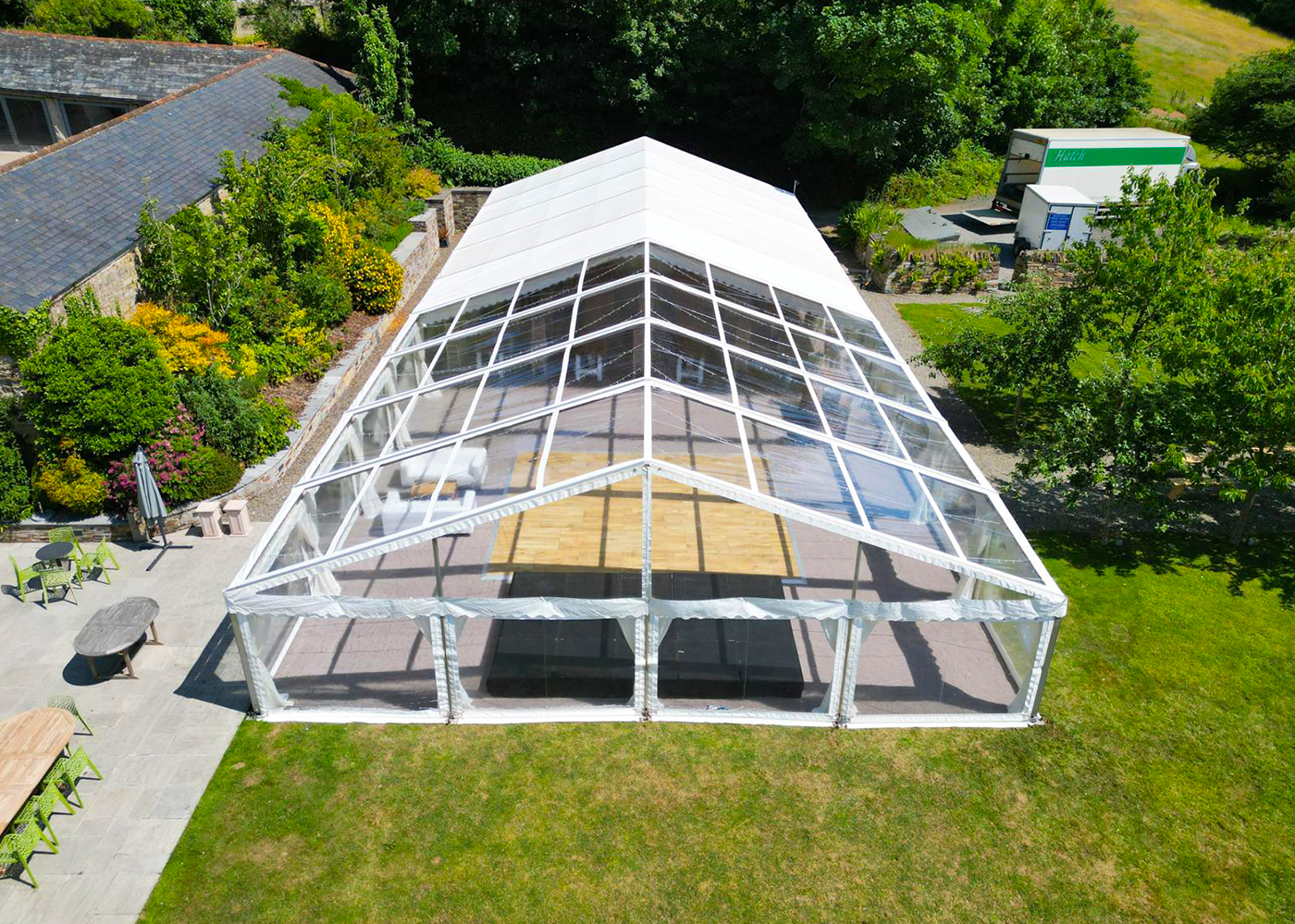 An aerial view of a large clear tent with a wooden floor.