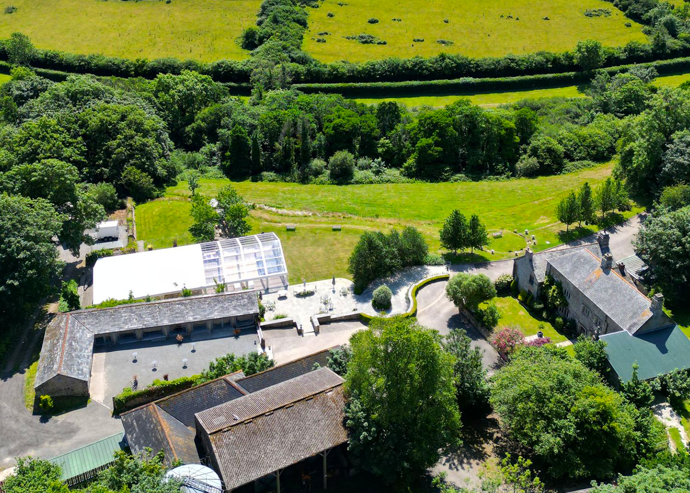 An aerial view of a farm with a lot of buildings and trees