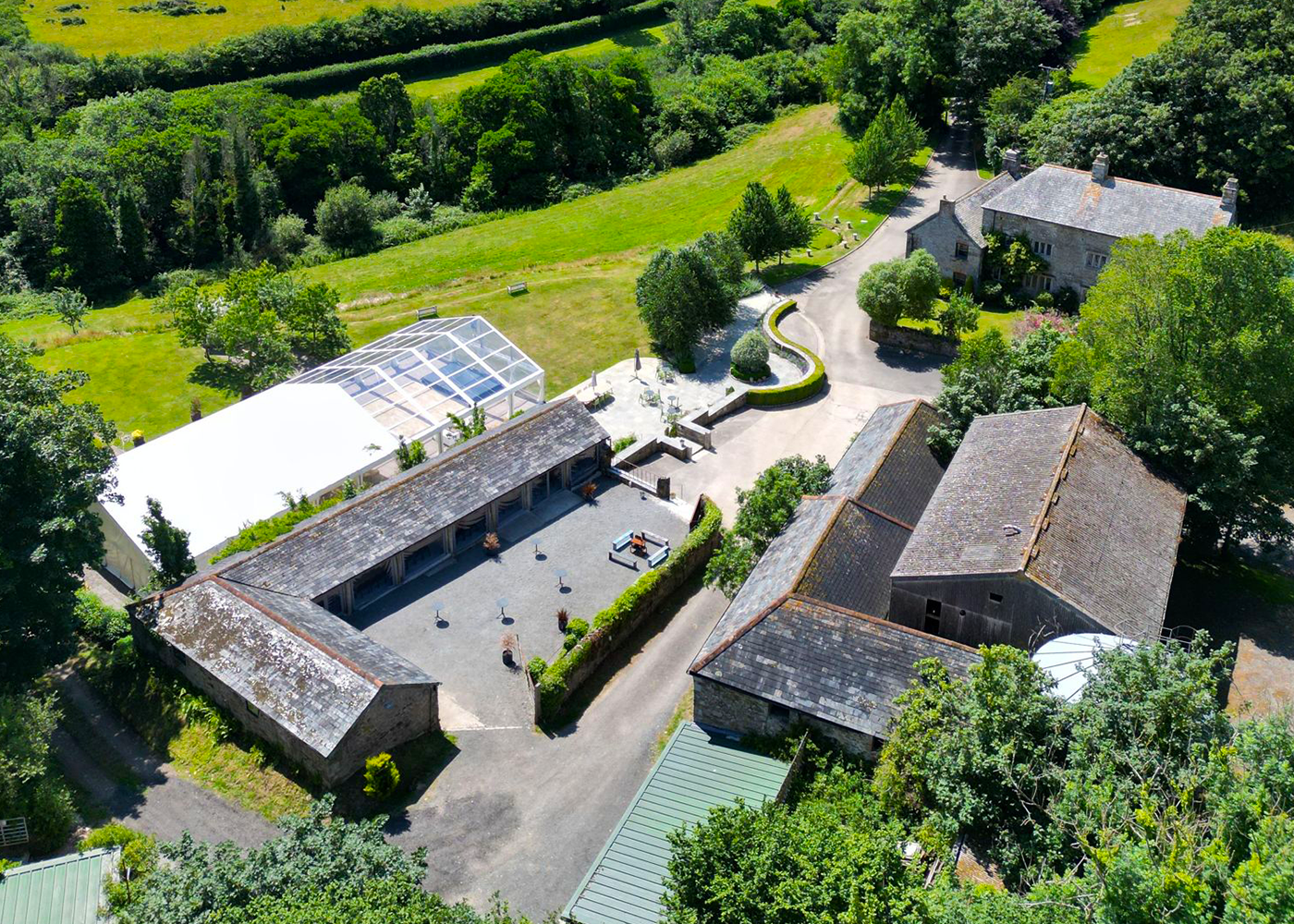 An aerial view of a farm with lots of buildings and trees.